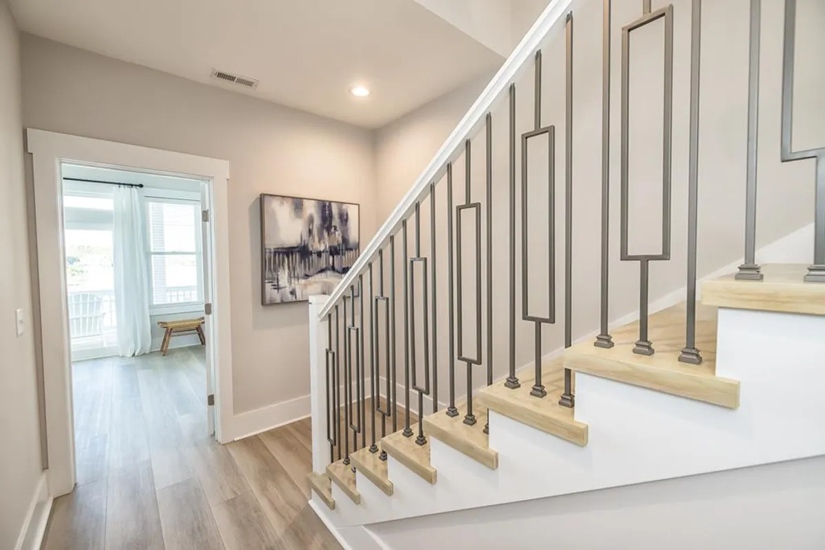 A view from the interior entrance area, showcasing a staircase bathed in natural light, with attractive wall art and a doorway leading outside. The atmosphere is warm and inviting, offering a sense of arrival and transition between home and the adventures awaiting outside.